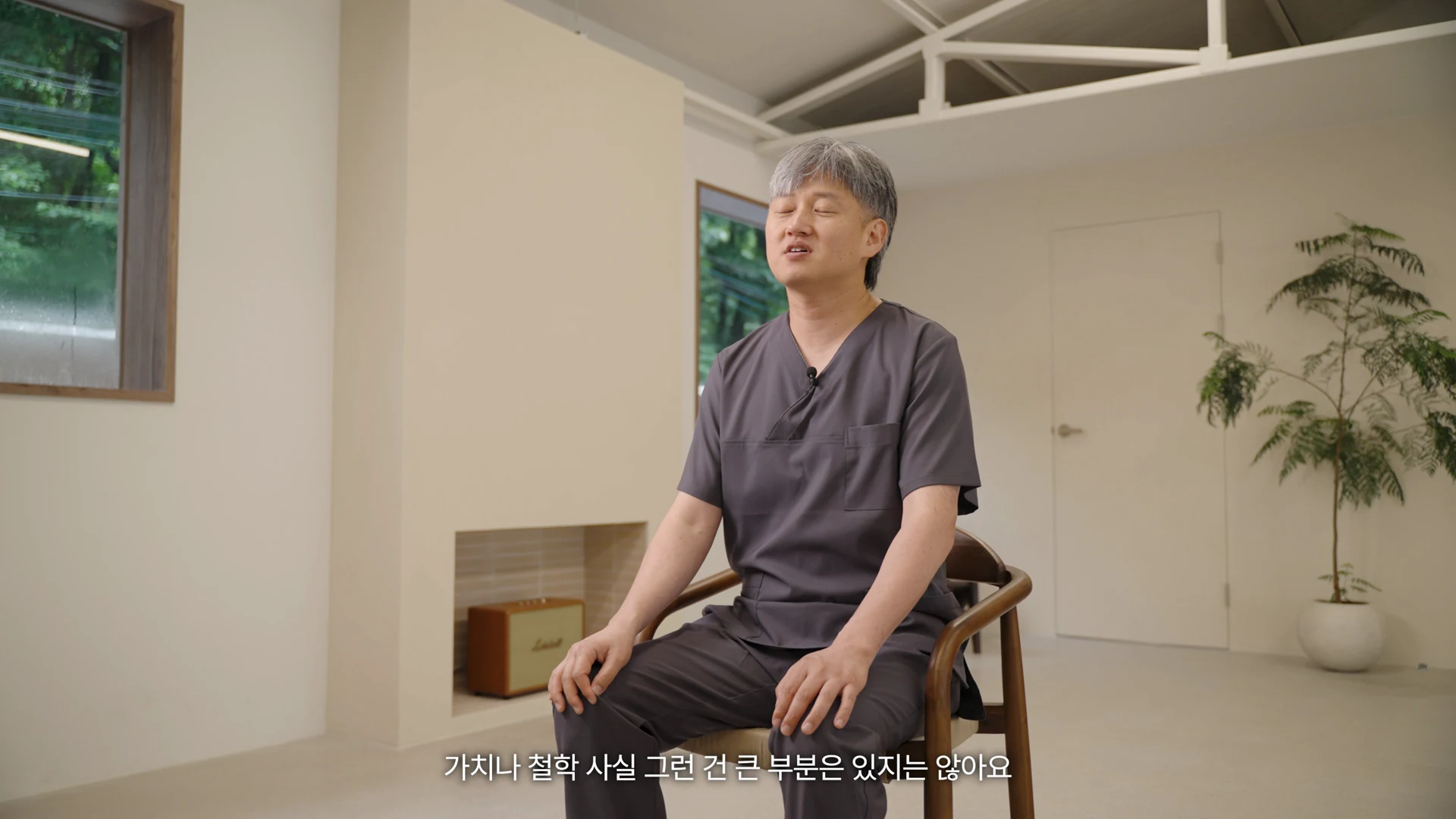 의자에 앉아 제작에 대한 생각을 설명하는 김병희 기공실장의 넓은 인터뷰 구도